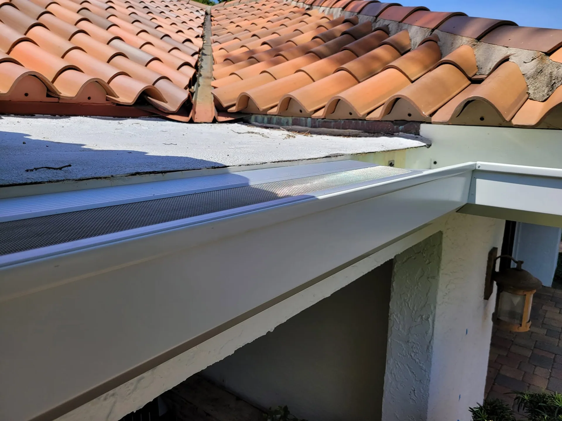Close up white gutter micro mesh guard flat roof clay tile lantern, Sanford